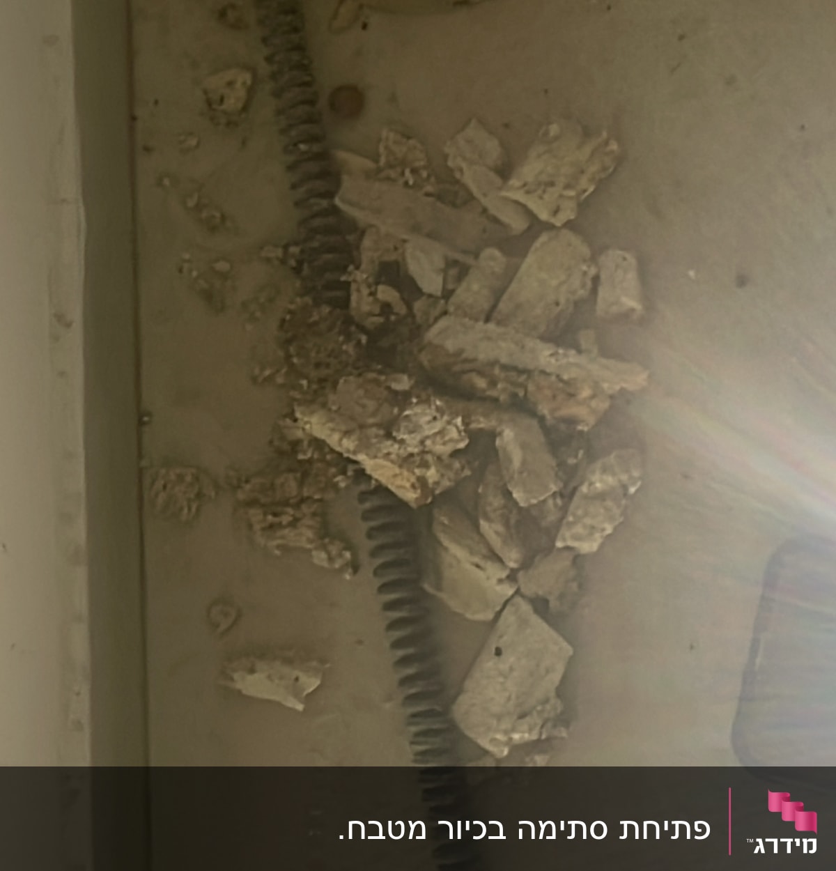 צינור גמיש עם שברי בטון על הרצפה